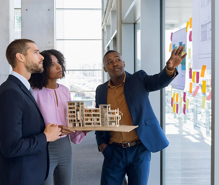 building-model-people-meeting Real estate investment solutions - Advisor explaining them